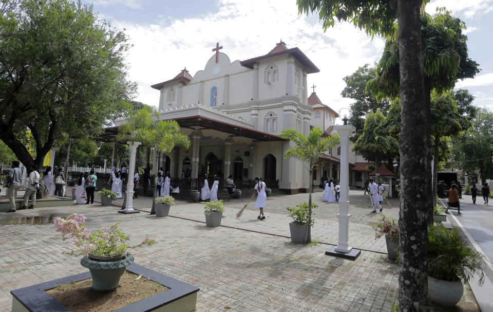 People clean the courtyard of the St. Sebastian's church, one of the sites of the Easter Sunday attacks, as they wait to welcome the Archbishop of Canterbury Justin Welby in Katuwapitiya village, Negombo , Sri Lanka, Thursday, Aug. 29, 2019. The figurehead of the Church of England emphasized the need for Christian unity on Thursday as he paid tribute to the victims of the Easter Sunday bomb attacks at a Roman Catholic church in Sri Lanka. A total of 263 people were killed when seven suicide bombers from a local Muslim group attacked three churches and three luxury hotels on April 21. (AP Photo/Eranga Jayawardena)