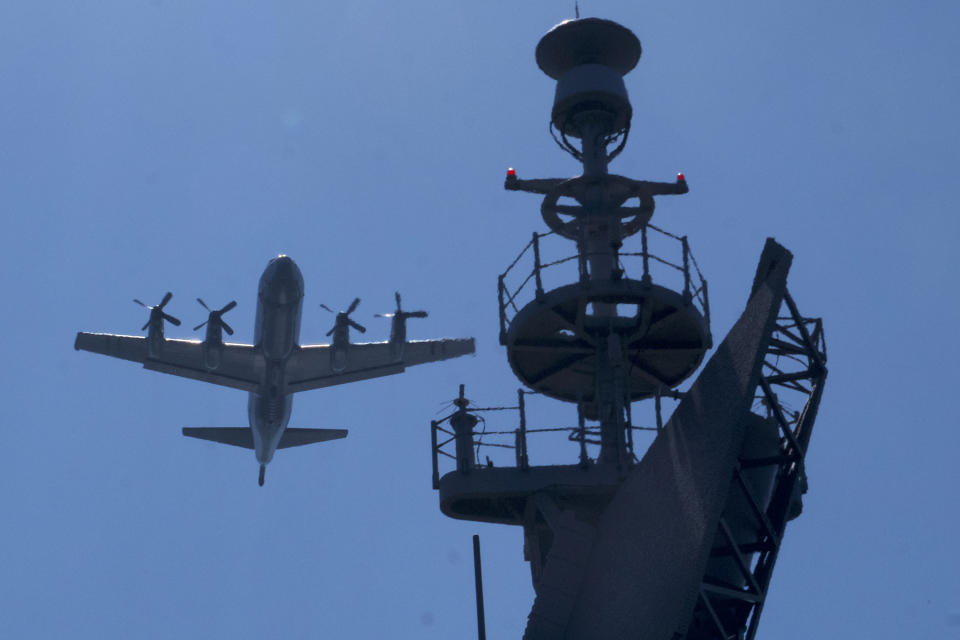 A P3C anti-submarine plane flies past the radar tower of a Taiwanese Keelung class destroyer during a patrol as part of the island's annual Han Kuang exercise off the island's eastern coast near the city of Yilan, Taiwan on Tuesday, July 26, 2022. The Taiwanese capital Taipei staged a civil defense drill Monday and Tsai on Tuesday attended the annual Han Kuang military exercises, although there was no direct connection with tensions over a possible Pelosi visit. (AP Photo/Huizhong Wu)