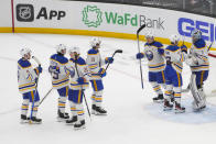 The Buffalo Sabres line up to greet goaltender Ukko-Pekka Luukkonen, far right, as they celebrate a 6-2 win over the Seattle Kraken in an NHL hockey game Monday, March 18, 2024, in Seattle. (AP Photo/Lindsey Wasson)