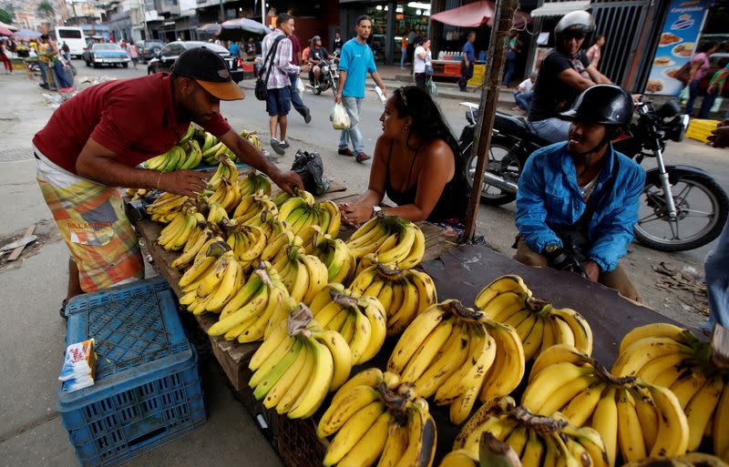 FILE PHOTO: Vendors sell bananas at a market in Caracas