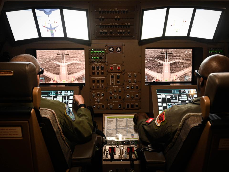 The boom operators' station with two men at the computers.