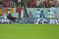 Morocco's goalkeeper Yassine Bounou saves a ball by Spain's Sergio Busquets during the penalties shoot out at the World Cup round of 16 soccer match between Morocco and Spain, at the Education City Stadium in Al Rayyan, Qatar, Tuesday, Dec. 6, 2022. (AP Photo/Julio Cortez)