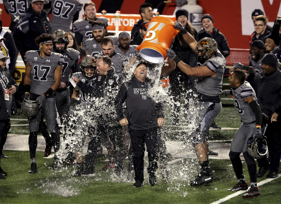 Utah head coach Kyle Whittingham gets dowsed with water from a cooler as Utah defeated Oregon in an NCAA college football game at Rice Eccles Stadium in Salt Lake City on Saturday, Nov. 20, 2021. (Scott G Winterton/The Deseret News via AP)