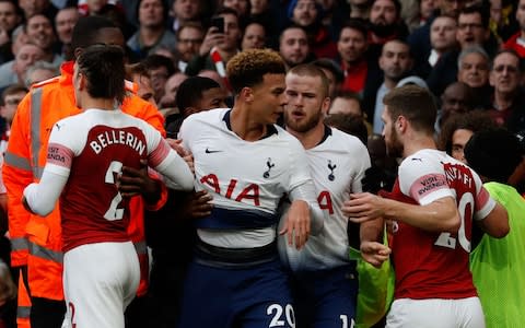 Tottenham Hotspur's English midfielder Dele Alli (C) is restrained after celebrating Dier's equalizer during the English Premier League football match between Arsenal and Tottenham  - Credit: AFP
