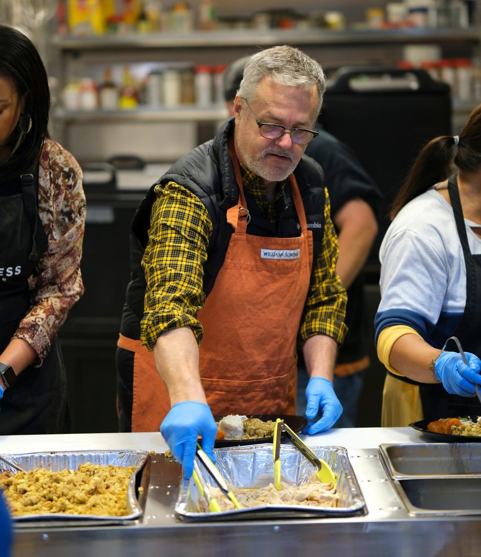 Dave Cathey, the "Food Dude" for The Oklahoman, serves food during the Thanksgiving meal at the Homeless Alliance Wednesday, November 23, 2022.
