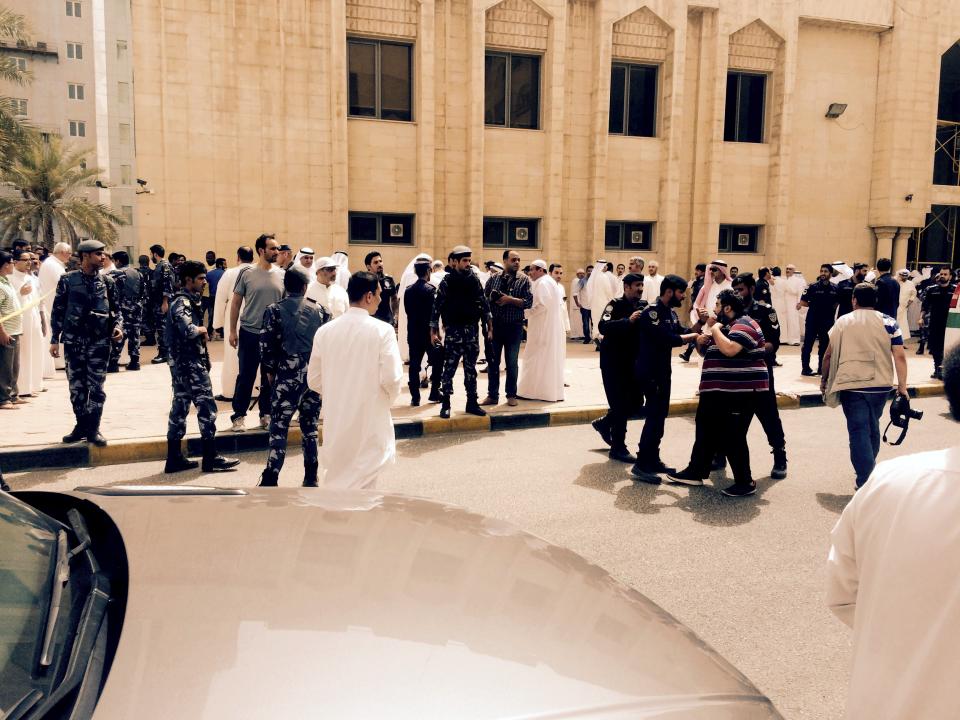 Police control the crowd in front of the Imam Sadiq Mosque after a bomb explosion in the Al Sawaber area of Kuwait City