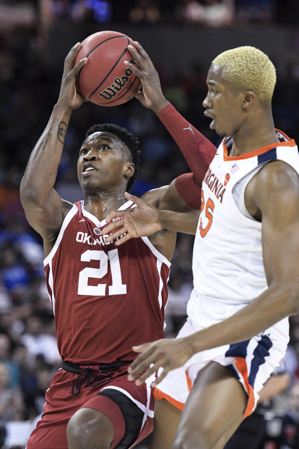 Oklahoma forward Kristian Doolittle (21) attempts a shot next to Virginia forward Mamadi Diakite (25) during the first half of a second-round game in the NCAA men's college basketball tournament Sunday, March 24, 2019, in Columbia, S.C. (AP Photo/Sean Rayford)