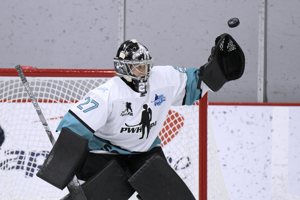 FILE - Team Sonnet goalie Erica Howe reaches for the puck during the first period of a hockey game against Team Bauer as part of the PWHPA Secret Dream Gap Tour on Friday, March 4, 2022, in Arlington, Va. In North America, the seven-team Premier Hockey Federation has made significant inroads since being established as a four-team league in 2015 by expanding into Canada and raising its salary cap to $1.5 million per franchise starting next season. (AP Photo/Nick Wass, File)