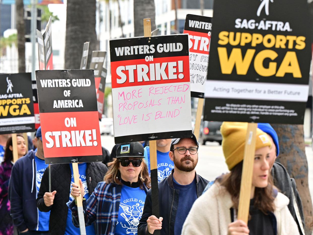 Writers on strike march with signs on the picket line on day four of the strike by the Writers Guild of America in front of Netflix in Hollywood, California on May 5, 2023.