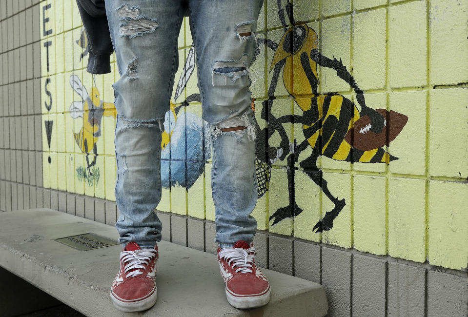 An Alameda High School student poses for photos wearing ripped jeans on the school's campus in Alameda, Calif., Thursday, Aug. 23, 2018. The relaxed new dress code at public schools in the small city of Alameda, across the bay from San Francisco, is intentionally specific: Midriff-baring shirts are acceptable attire, so are tank tops with spaghetti straps and other once-banned items like micro-mini skirts and short shorts. (AP Photo/Jeff Chiu)