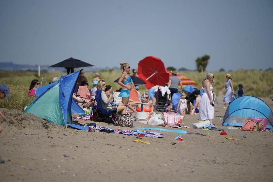 People enjoying the weather and trying to keep cool at Malahide beach near Dublin (Niall Carson/PA) (PA Wire)