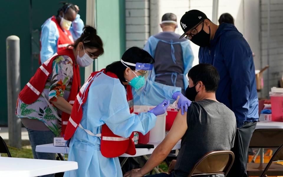 In this Jan. 13, 2021, file photo, health care workers receive a COVID-19 vaccination at Ritchie Valens Recreation Center, in Pacoima, Calif. California will require all of its roughly 2.2 million health care and long term care workers to be fully vaccinated against the coronavirus by Sept. 30. Gov. Gavin Newsom said last month he would require health care workers to either be vaccinated or submit to weekly testing. (AP Photo/Marcio Jose Sanchez, File) - AP