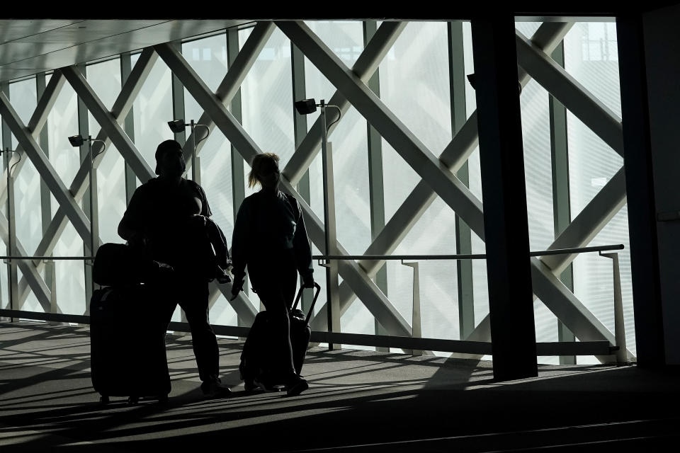 Travelers walk toward terminals at San Francisco International Airport during the coronavirus outbreak in San Francisco, Tuesday, Nov. 24, 2020. (AP Photo/Jeff Chiu)