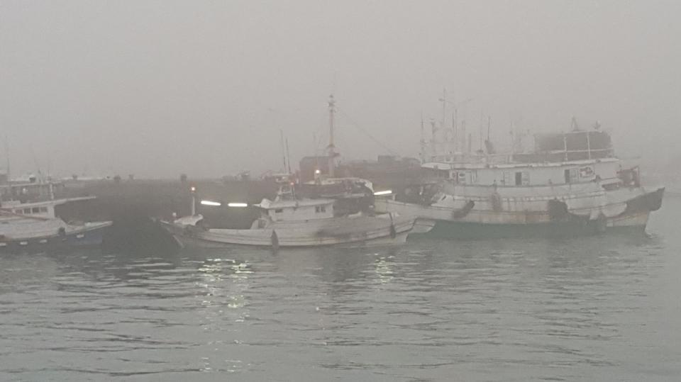  澎湖地區19日清晨受濃霧影響，行駛中車輛與進出港卸 貨的漁船，都必須開燈行駛。 中央社