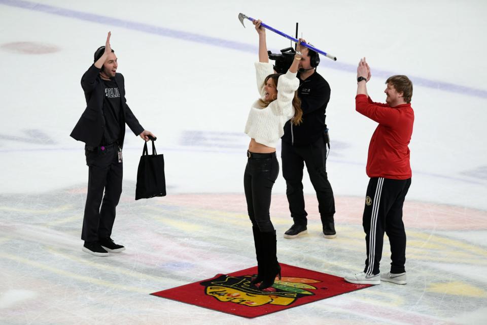 Model Cindy Crawford, center, celebrates after making a shot between periods during a game between the Chicago Blackhawks and the Detroit Red Wings at United Center in Chicago on Sunday, Feb. 25, 2024.
