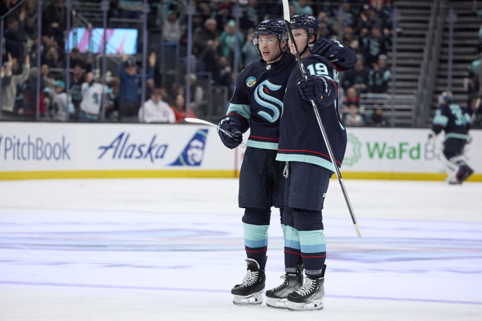 Seattle Kraken defenseman Vince Dunn, left, is congratulated by left wing Jared McCann (19) after scoring the tying goal against the Philadelphia Flyers during the third period of an NHL hockey game Friday, Dec. 29, 2023, in Seattle. (AP Photo/John Froschauer)