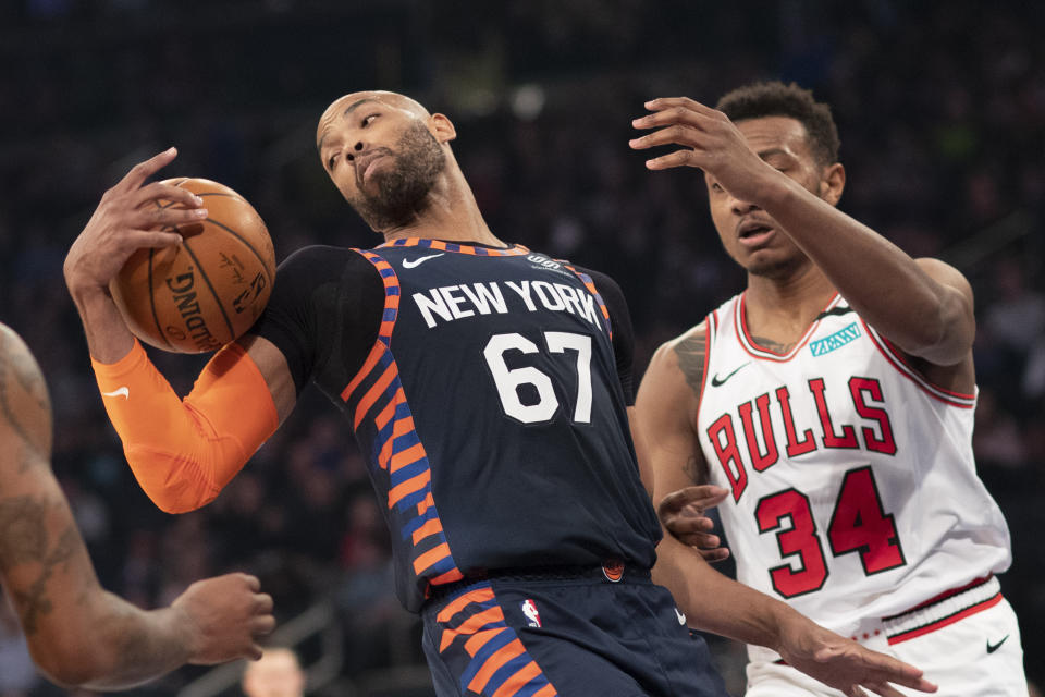 New York Knicks center Taj Gibson (67) pulls down a rebound in front of Chicago Bulls center Wendell Carter Jr. (34) during the first half of an NBA basketball game, Saturday, Feb. 29, 2020 in New York. (AP Photo/Mark Lennihan)