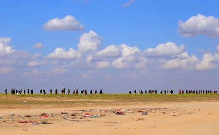 FILE PHOTO: Civilians walk together near Baghouz, Deir Al Zor province, Syria March 6, 2019. REUTERS/Rodi Said/File Photo