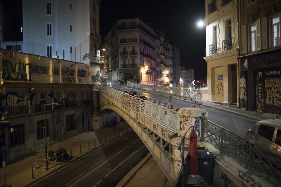 Empty streets are pictured after curfew in Marseille, southern France, Sat, Oct. 24, 2020. The curfew imposed in eight regions of France last week, including Paris and its suburbs, is being extended to 38 more regions and Polynesia. (AP Photo/Daniel Cole)