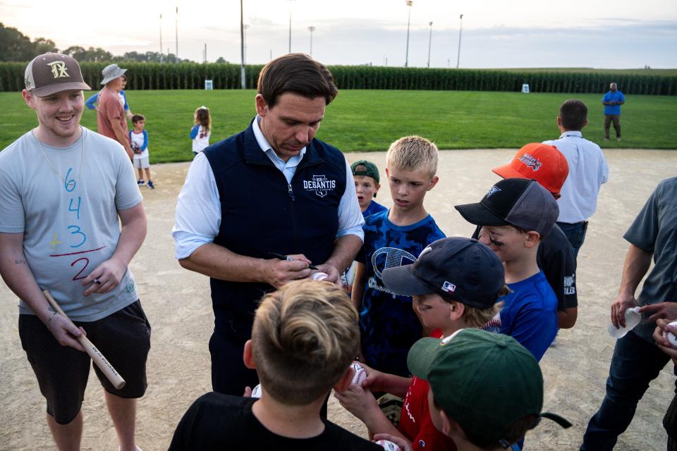 Gov. Ron DeSantis autographs baseballs during an event at the Field of Dreams movie site on Thursday, August 24, 2023 in Dyersville.