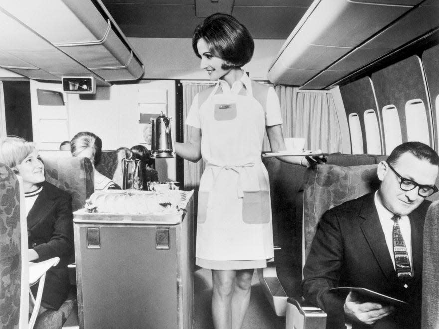 Pan Am flight attendant serving drinks on the company's 747.