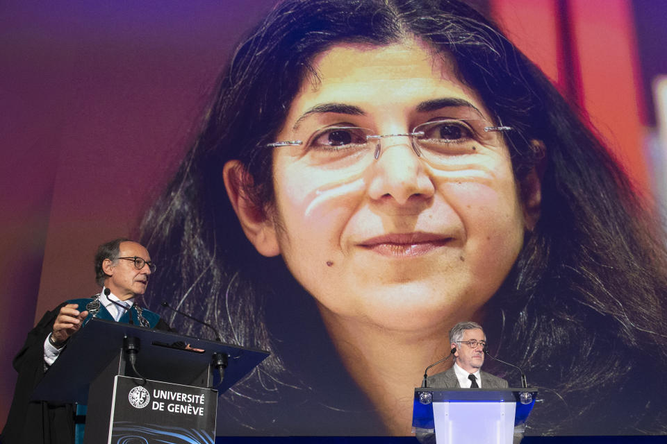 FILE - Yves Flueckiger, left, Rector of the university of Geneva, next to Roland Marchal, right, researcher at CERI, in front of the picture of French-Iranian anthropologist Fariba Adelkhah, placed under house arrest in Iran, as he delivers his speech, during the ceremony Dies Academicus of the University of Geneva, in Geneva, on Oct. 9, 2020. Paris' political sciences institute Sciences Po announced on Wednesday Oct. 18, 2023 that French-Iranian academic Fariba Adelkhah, who has previously been detained in Iran, has returned to France. (Salvatore Di Nolfi/Keystone via AP, File)