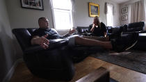 Mike Gilpatrick, who as a teenager was incarcerated at the Youth Development Center, talks with his wife Kelly, who as stood with him over their 16 years of marriage, in the living room of their home, Wednesday, Sept. 8, 2021, in Nashua, N.H. Gilpatrick, 38, filed a lawsuit Monday Sept. 13, alleging he was physically and sexually abused at the former YDC in Manchester, which has been the target of a criminal investigation since 2019 and is slated to close in 2023. (AP Photo/Charles Krupa)