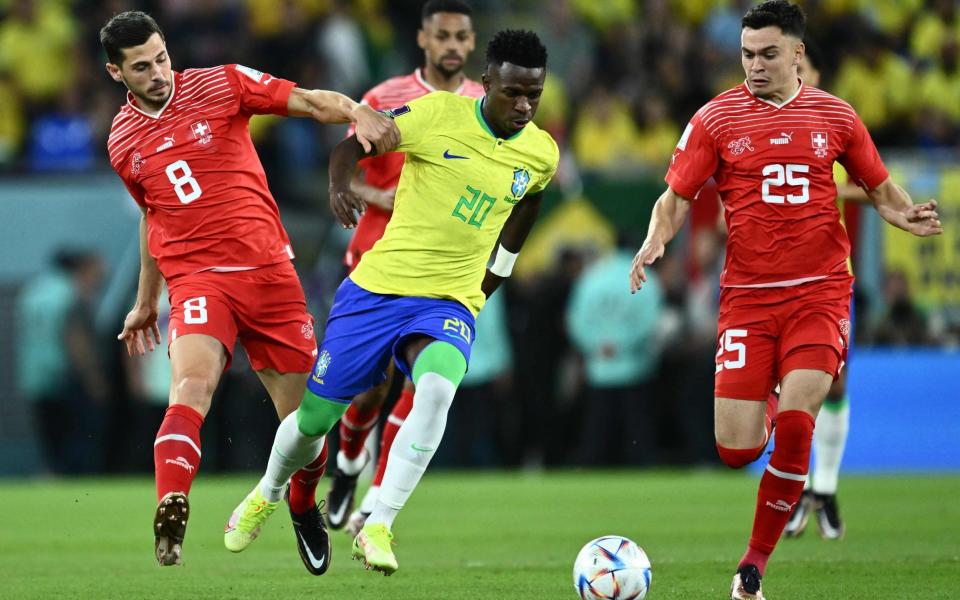 Number 8 Remo Freuler fights for the ball with Brazil's forward #20 Vinicius Junior as Switzerland's midfielder #25 Fabian Rieder watches on - AFP