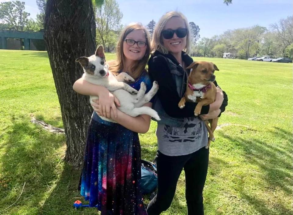 Dana Robinson, right, with her 11-year-old daughter, Lola, while holding their two dogs, Rosie and Willow.