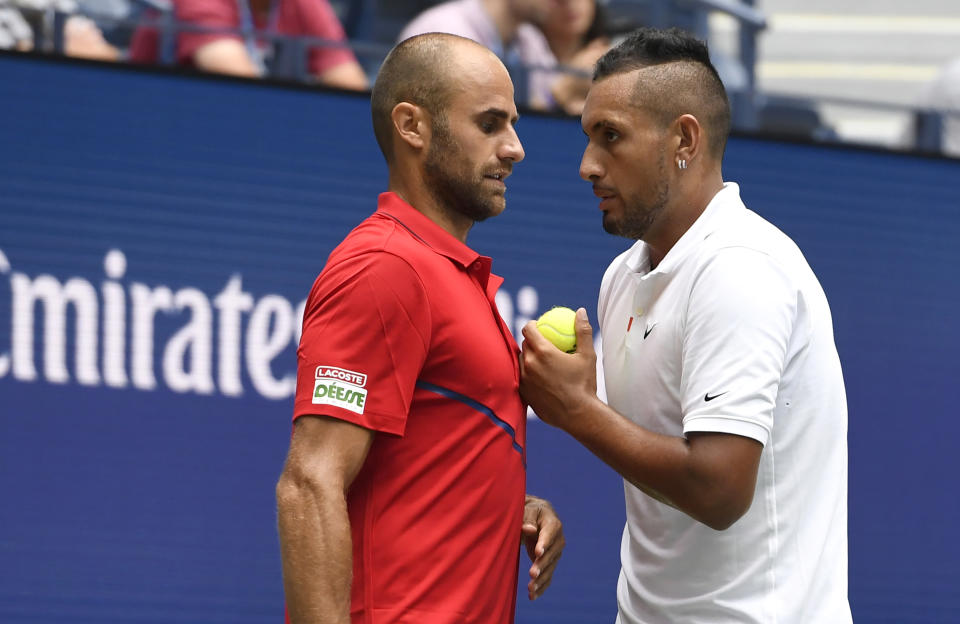 Nick Kyrgios, of Australia, right, talks with doubles partner Marius Copil, of Romania, during a first round match against Ken Skupski, of the United Kingdom, and Marcus Daniell, of New Zealand, during the US Open tennis championships Friday, Aug. 30, 2019, in New York. (AP Photo/Sarah Stier)