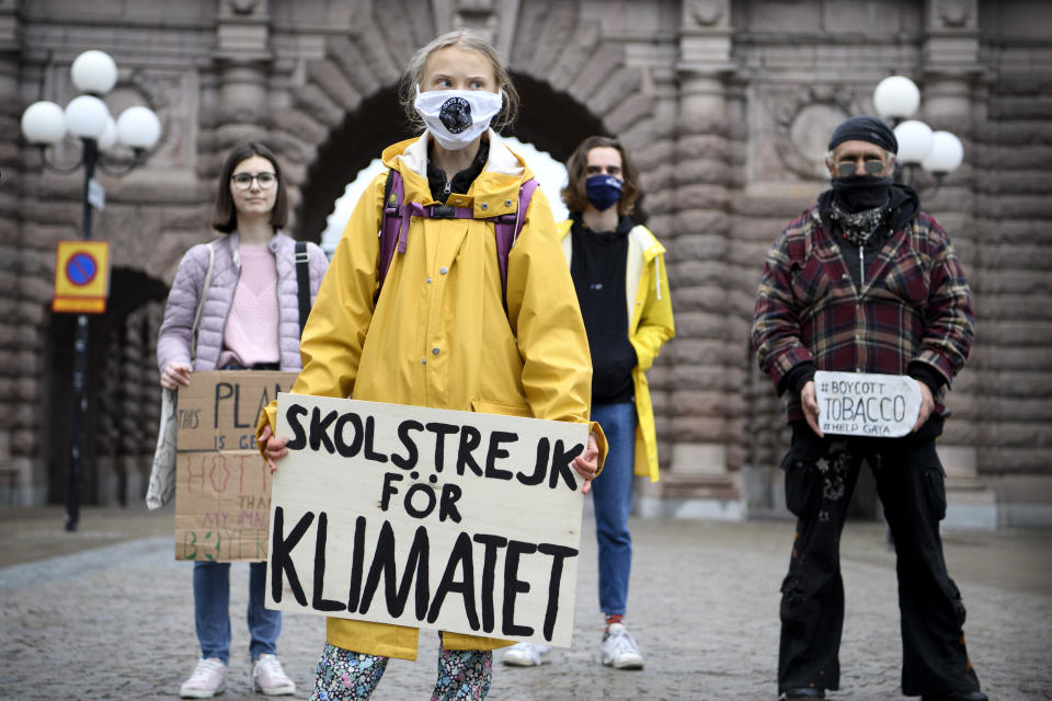 Swedish climate activist Greta Thunberg, foreground center, holds a sign with writing reading in Swedish "School Strike for Climate" as attends a Fridays For Future protest outside the Swedish Parliament, in Stockholm, Sweden, Friday, Oct. 9, 2020. The winner of this year's Nobel Peace Prize will be announced Friday at 11 a.m. (0900 GMT) in Oslo, with no shortage of causes or candidates on this year's list. Guesses — and bets — this year have focused on Swedish climate activist Greta Thunberg amongst others. (Jessica Gow/TT via AP)