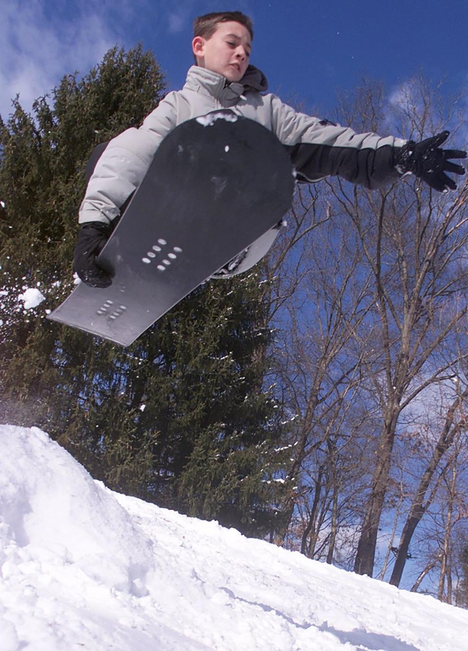 A boy snowboards at the Tavistock County Club in Haddonfield after a snowstorm in December 2000.