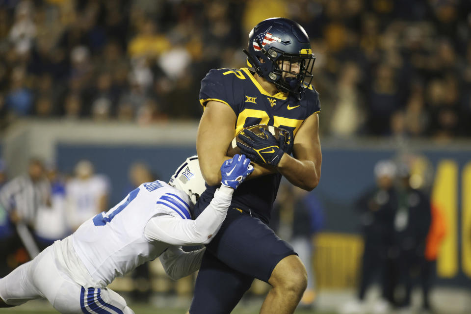 West Virginia's Kole Taylor (87) drags BYU's Jakob Johnson (0) into the end zone for a touchdown during the second half of an NCAA college football game on Saturday, Nov. 4, 2023, in Morgantown, W.Va. West Virginia won 37-7. (AP Photo/Chris Jackson)