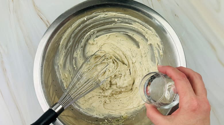 hand pouring water into dressing