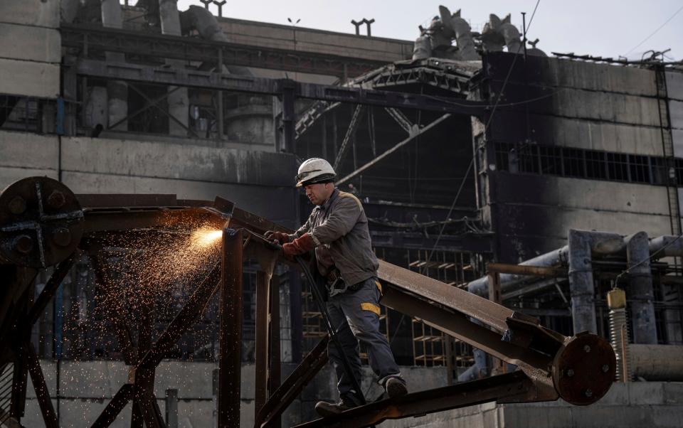 A worker cuts metal after a Russian missile attack at DTEK's power plant in Ukraine