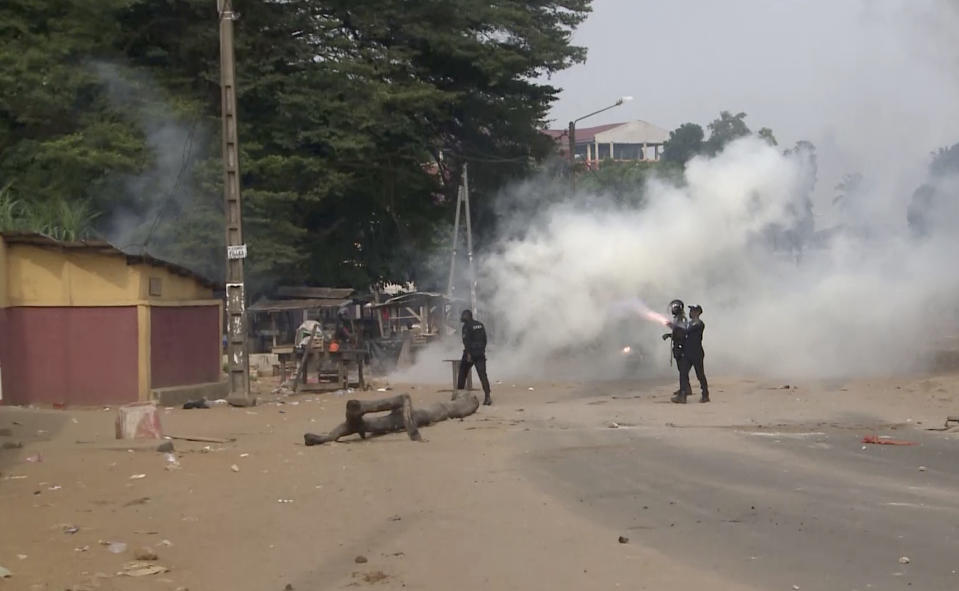 In this image made from video, security forces fire tear gas after a group of local residents demonstrated outside a coronavirus medical reception facility that was under construction in the Yopougon area of the commercial capital Abidjan, Ivory Coast, Monday, April 6, 2020. The protesters hampered the government's effort to build the emergency coronavirus medical reception facility in the crowded Yopougon area, ransacking the site and destroying equipment to be used to construct the center, saying they are worried that the triage center could expose their community to COVID-19. (AP Photo)