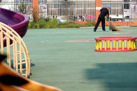 <p>A person wearing protection on his shoes and head, sweeps near the scene of an explosion at a kindergarten in Fengxian County in Jiangsu Province, China, June 16, 2017. (Photo: Aly Song/Reuters) </p>