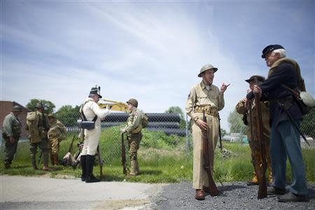 Re-enactors Bill Cashin, of World War II, Jim Tennyson, of the Revolutionary War, and John Lucas, of the Civil War, line up before marching in the Gettysburg Memorial Day parade in Gettysburg, Pennsylvania, May 26, 2014. REUTERS/Mark Makela