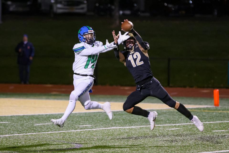 Logan Booker of Corning intercepts a pass meant for Cicero-North Syracuse's Mason Ellis. CNS won the regional championship 20-16.