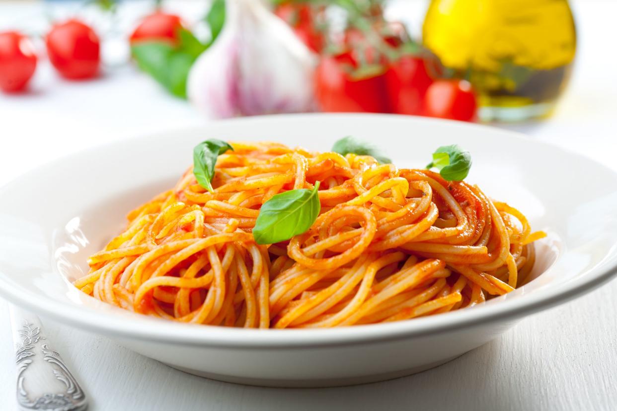 Plate of penne  with ingredients in the background.