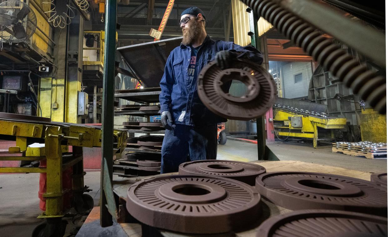 A worker handles chemically-bonded sand cores made that are used to produce the internal parts of castings for a commercial truck rotors Thursday, May 18, 2023 at Waupaca Foundry in Waupaca, Wis. The foundry has seen an increase in business from companies seeking to lessen their reliance on parts made in China and India.