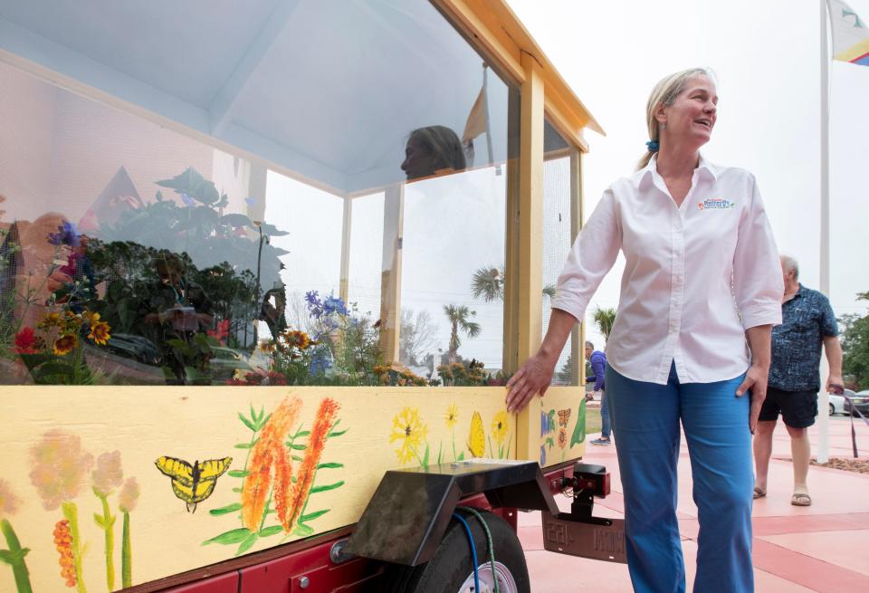 Jenny Weber, head of the Panhandle Butterfly House and Nature Center, unveils the organization&#39;s new mobile facility outside St. Sylvester Catholic Church in Navarre on Tuesday.