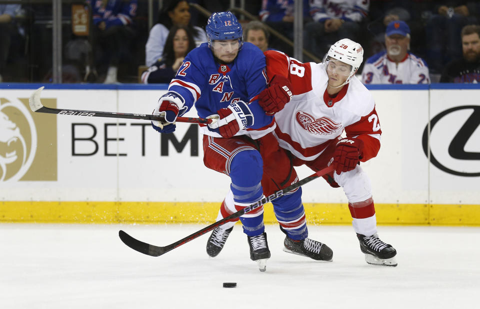 New York Rangers right wing Julien Gauthier, left, and Detroit Red Wings defenseman Gustav Lindstrom battle for the puck during the first period of an NHL hockey game Sunday, Nov. 6, 2022, in New York. (AP Photo/John Munson)