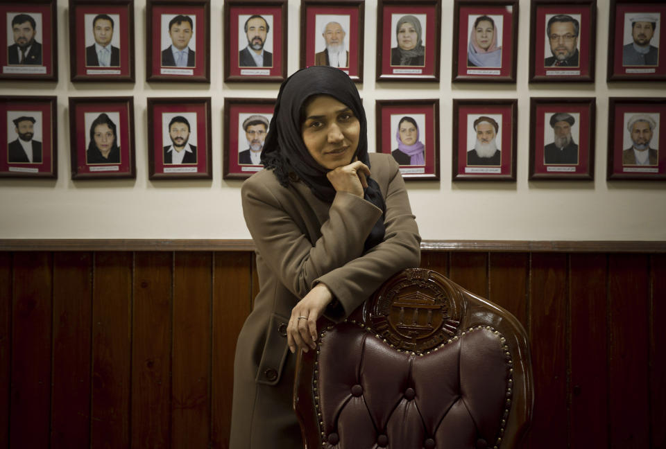 In this Wednesday, March 26, 2014 photo, Afghan lawmaker Habiba Danish from Takhar poses next to the picture wall showing Afghanistan’s 249 parliamentarians in the parliament in Kabul, Afghanistan. Under Afghan law, 20 percent of council member seats are reserved for women, who are also figuring prominently in presidential campaigns. Three presidential hopefuls have taken the bold step of choosing a woman as a running mate, including one of the front-runners. (AP Photo/Anja Niedringhaus)