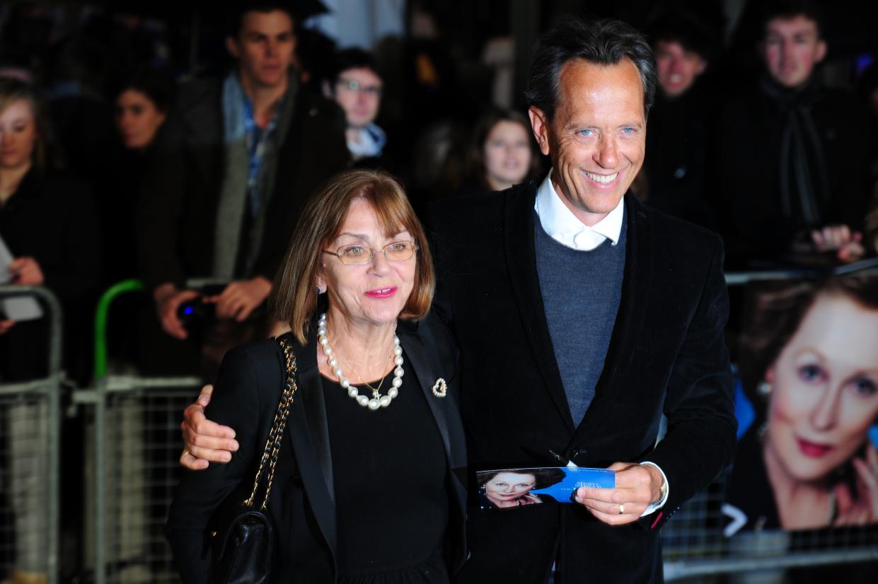 British actor Richard E Grant (R) poses with his wife Joan Washington (L) on the blue carpet as she arrives to attend the European premiere of the film 