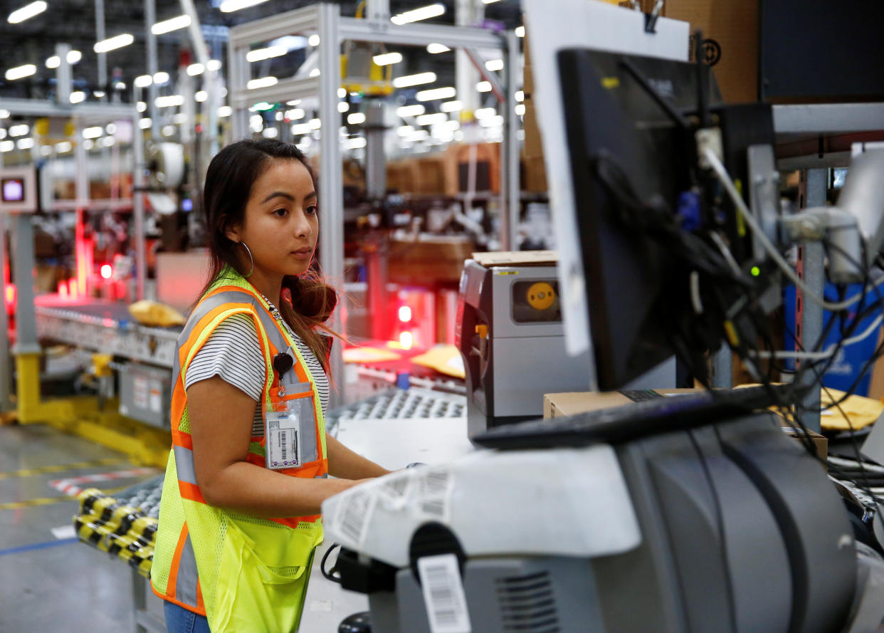 Employee Stanaleen Greenman works on processing packages kicked out by the automated scanning and labeling system at the Amazon fulfillment center in Kent, Washington, U.S., October 24, 2018.  REUTERS/Lindsey Wasson