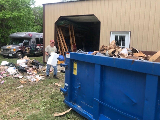 Dave Stansbury, a member of Tabernacle of Praise on U.S. 50, cleans up damage from Friday morning's flash floods that inundated the area. Stansbury was helping Pastor Gary Thomas, whose garage was flooded. In the background is the church bus. Thomas said flood waters reached the top of the front grille.