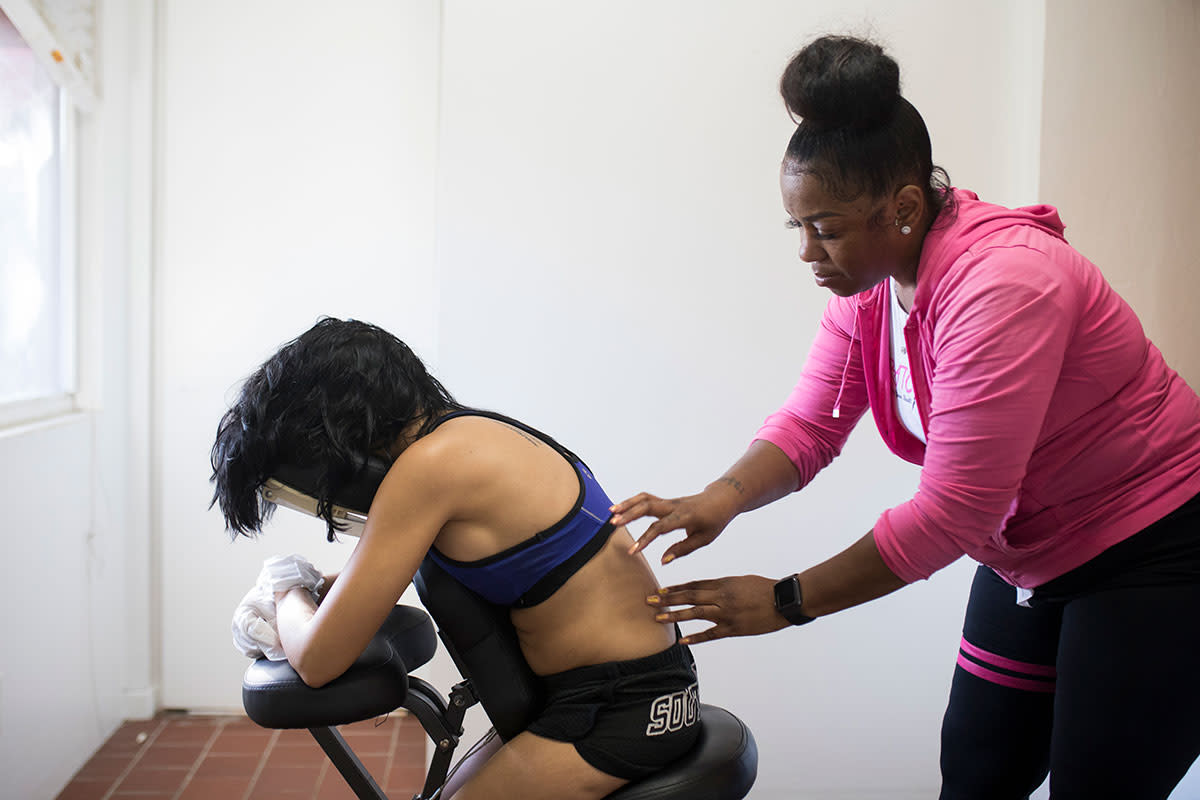 Toni George, owner of Scratcher Girls, scratches client Daria Ortiz in Hollywood, Fla.