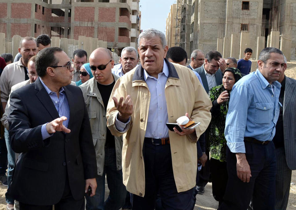 FILE - In this Nov. 24, 2013 file photo, Ibrahim Mehlib, center, tours a government housing project in Ismailiya, Egypt. On Sunday, Feb. 2, 2014, Egypt's new Prime Minister Ibrahim Mehlib urged a halt to protests and strikes to give the nation a breather to rebuild after more than three years of deadly turmoil, a call made by his predecessors to no avail. The turmoil sweeping Egypt since the 2011 ouster of Hosni Mubarak has devastated the economy, particularly the vital tourism sector. (AP Photo/Khaled Kandil, File)