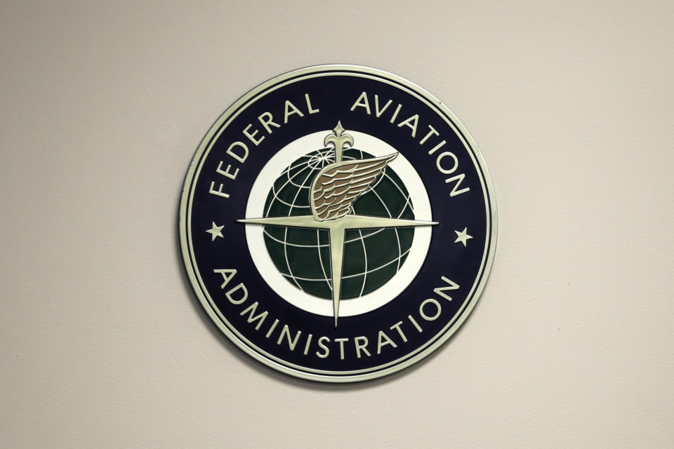 FILE - A Federal Aviation Administration sign hangs in the tower at John F. Kennedy International Airport in New York, March 16, 2017. Federal safety regulators are warning airlines to make sure that workers stay away from jet engines that are still running. The Federal Aviation Administration said Friday, Aug. 25, 2023, that the alert follows “multiple" incidents of workers being hurt or killed during ground operations. (AP Photo/Seth Wenig, File)